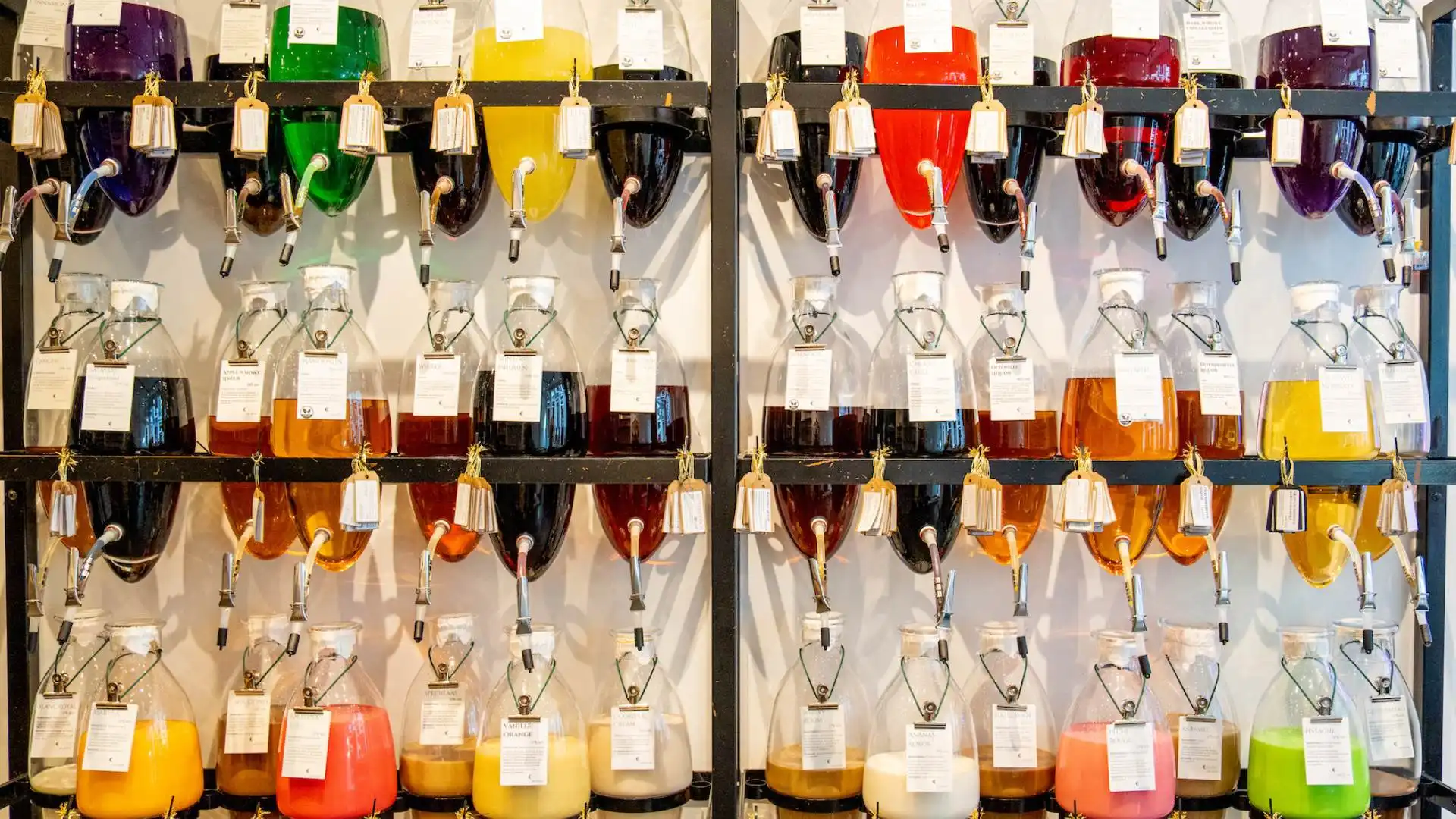 Glazen amforen met likeuren in de winkel van Miracle Liquors