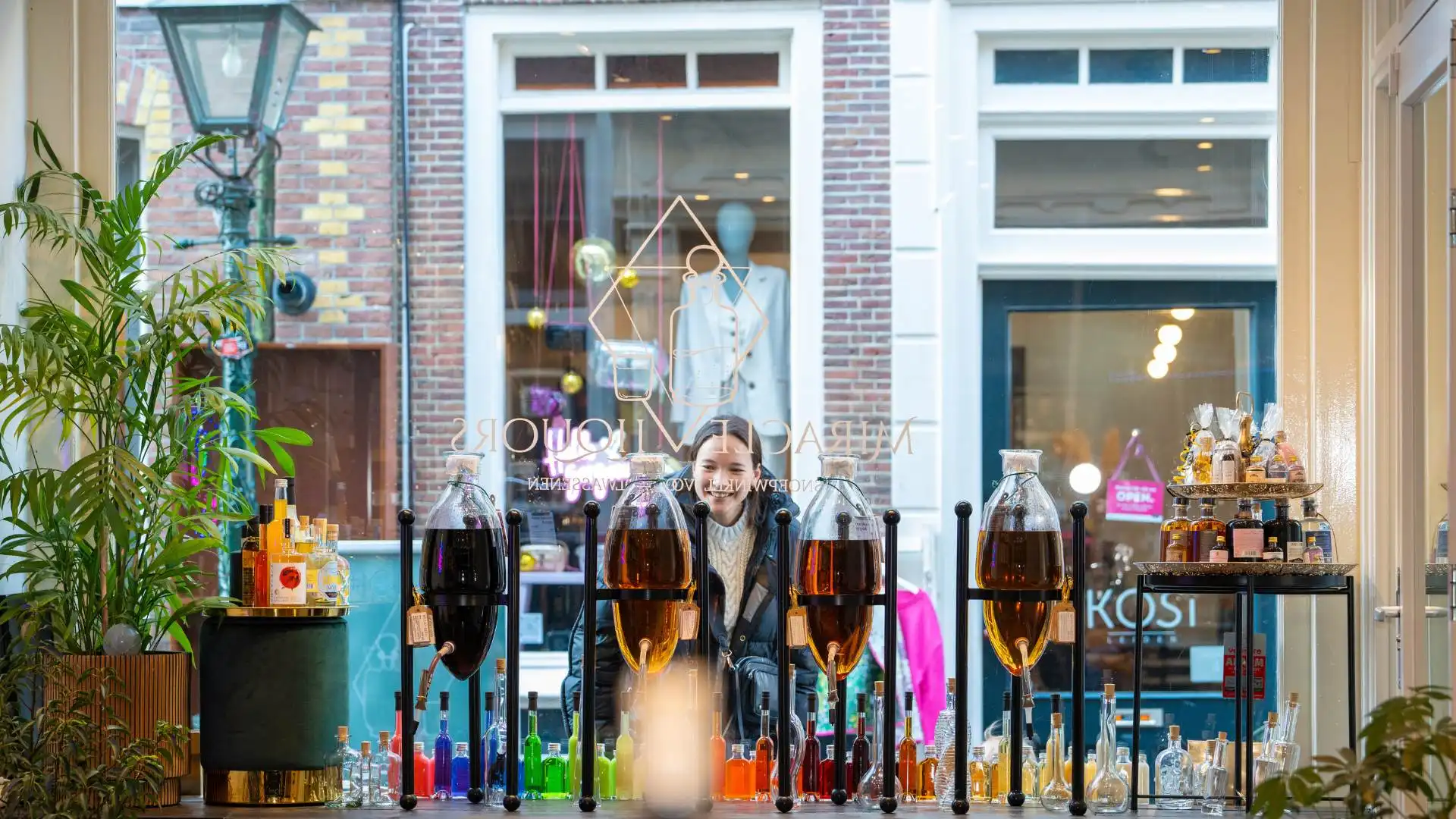 Glazen amforen met likeuren in de winkel van Miracle Liquors
