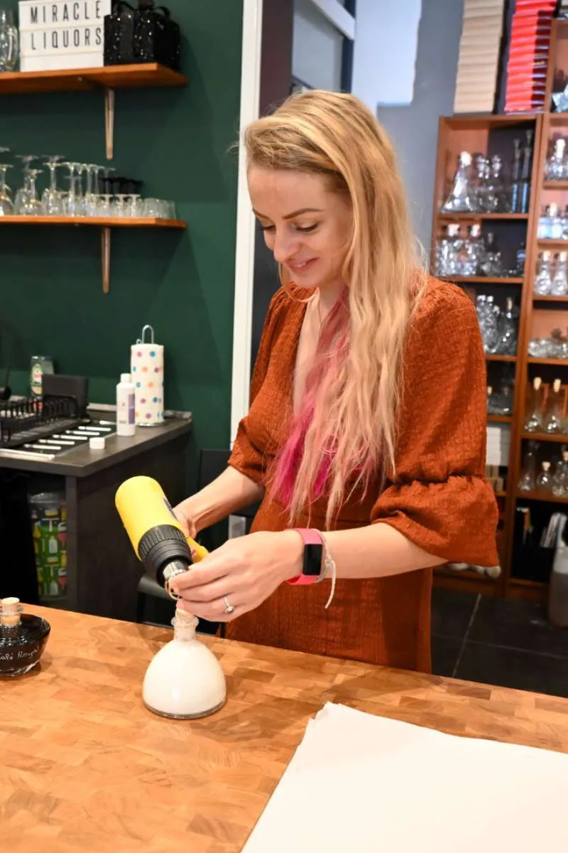 Merel Kool vult een fles bij Miracle Liquors